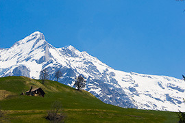 swiss chalet and snow capped mountains